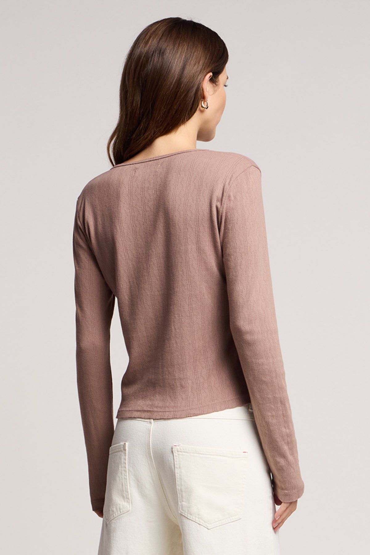 A person with long brown hair is shown from the back wearing the Velvet by Graham & Spencer ZELDA CARDIGAN in mauve and white pants, against a plain background.