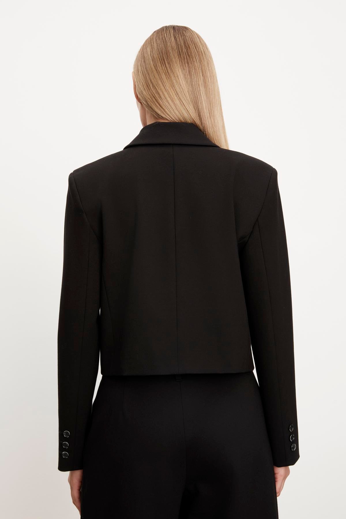   The back view of a person wearing a Velvet by Graham & Spencer ANYA PONTI CROPPED BLAZER. 