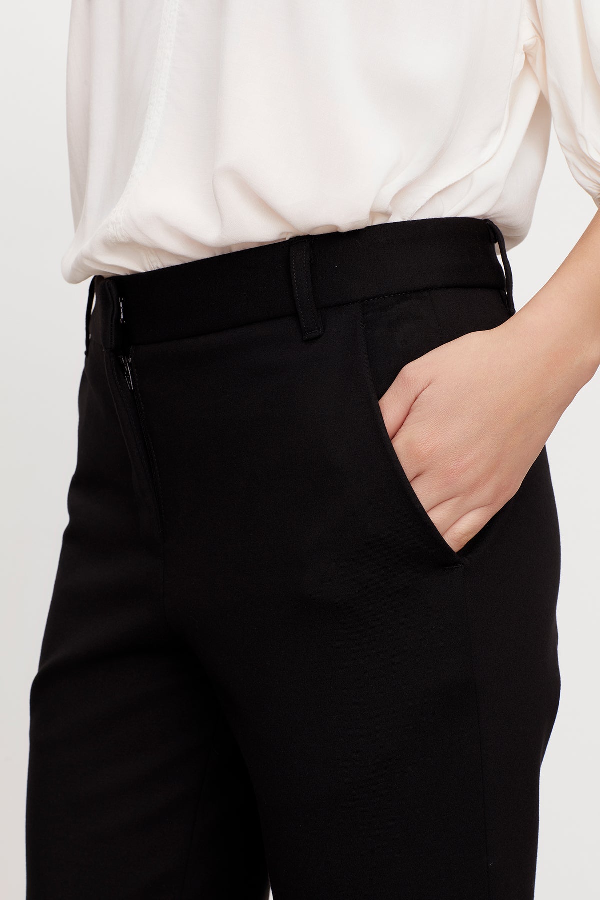   A woman is wearing Velvet by Graham & Spencer's JAY PONTI STRAIGHT LEG PANT in a cropped length with a white shirt. 