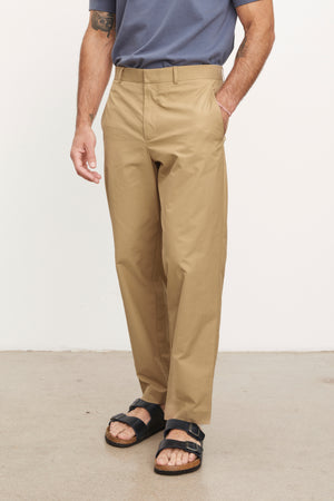 The man is wearing STING POPLIN PANT by Velvet by Graham & Spencer and sandals.