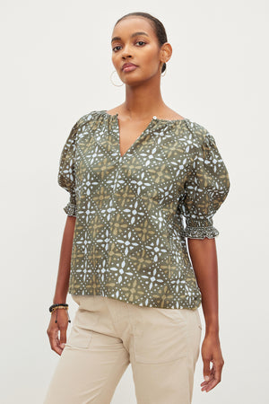 The model is wearing a Velvet by Graham & Spencer ALEX PRINTED BLOUSE with a puff sleeve.