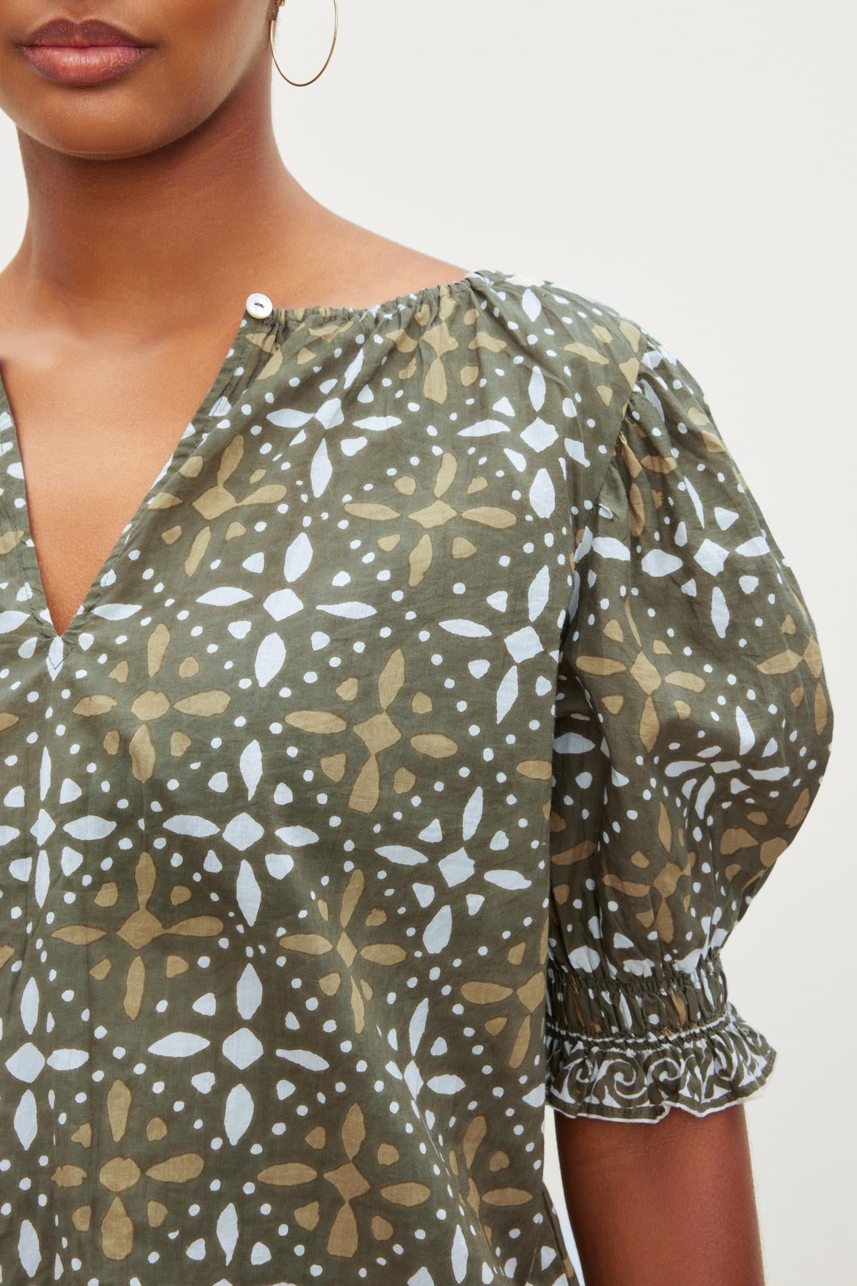 A woman wearing a Velvet by Graham & Spencer ALEX PRINTED BLOUSE with polka dots.-26799971696833