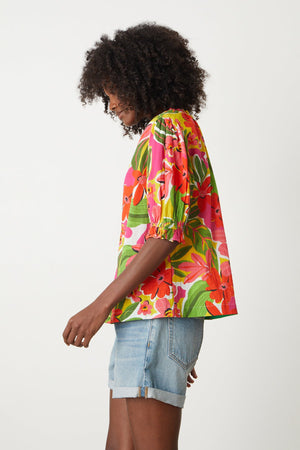 Carrie Boho Top in bold floral aloha print with reds, hot pinks and greens with blue denim shorts side