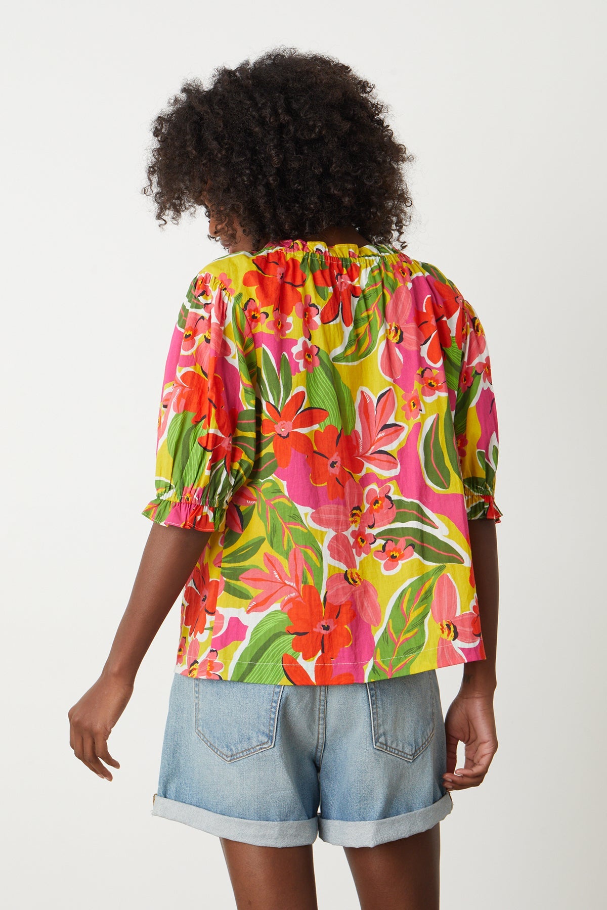   Carrie Boho Top in bold floral aloha print with reds, hot pinks and greens with blue denim shorts back 