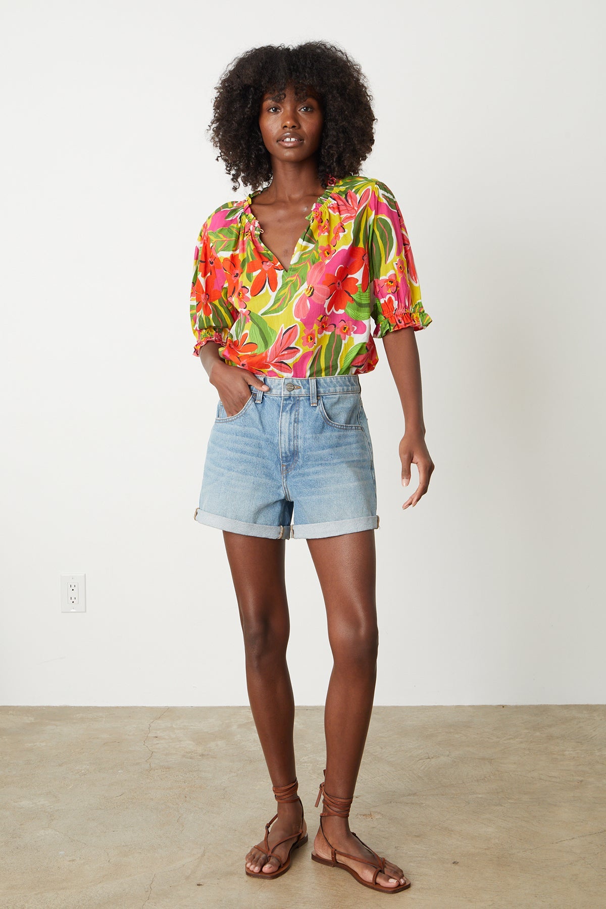 Carrie Boho Top in bold floral aloha print with reds, hot pinks and greens with blue denim shorts full length front-26715112898753