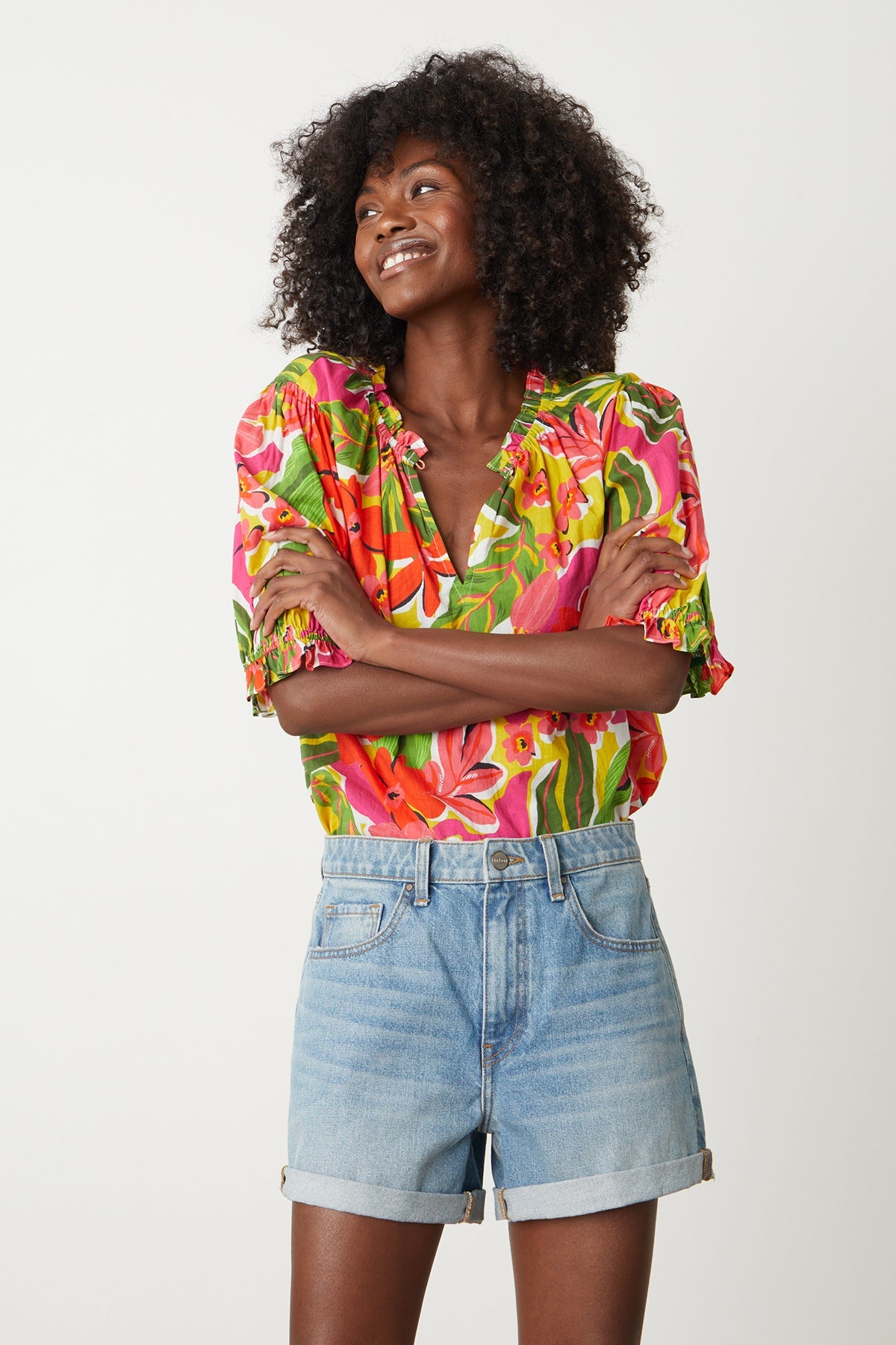   Carrie Boho Top in bold floral aloha print with reds, hot pinks and greens tucked into blue denim shorts 