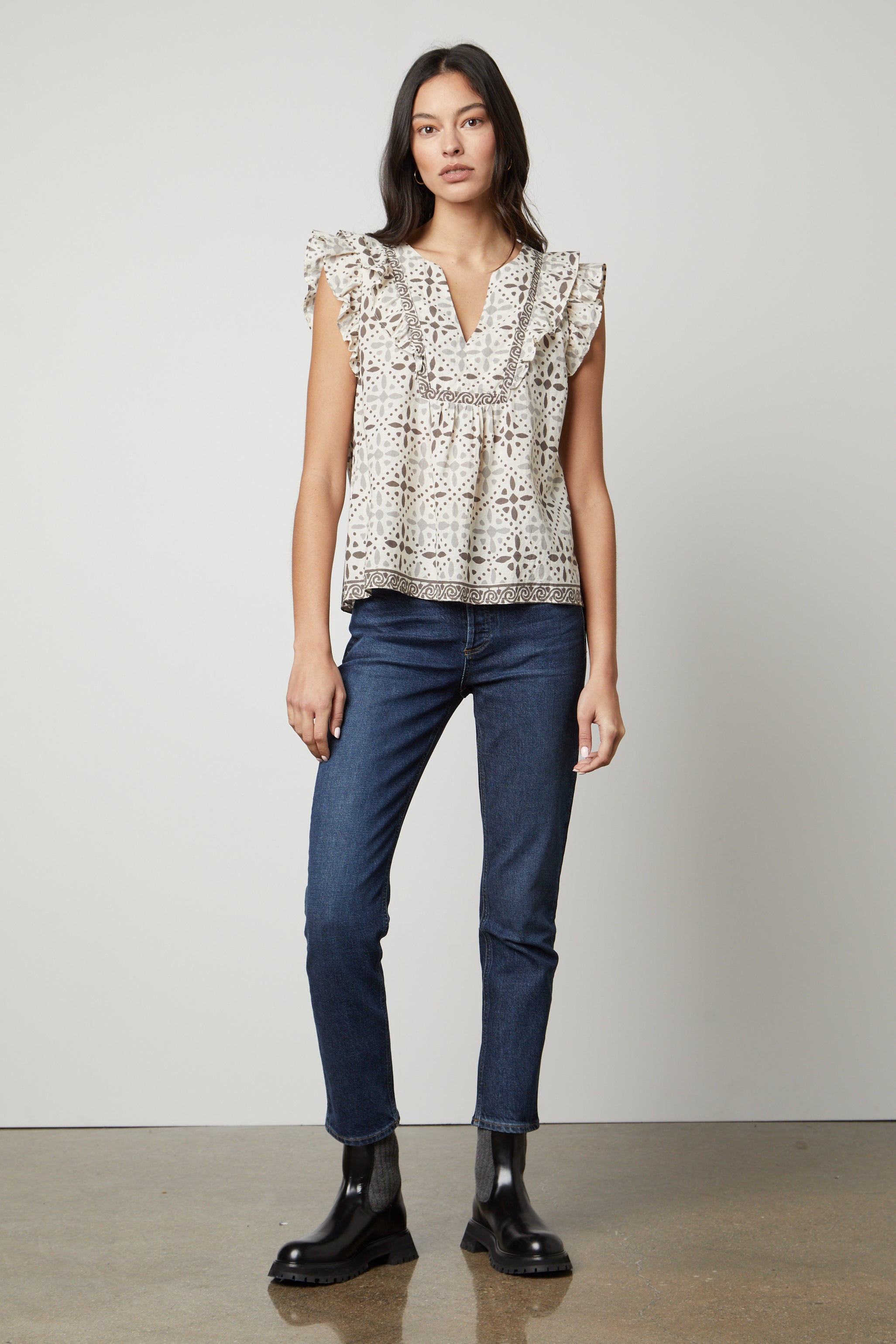   The model is wearing jeans and a CORIN PRINTED TANK TOP by Velvet by Graham & Spencer with ruffled sleeves. 