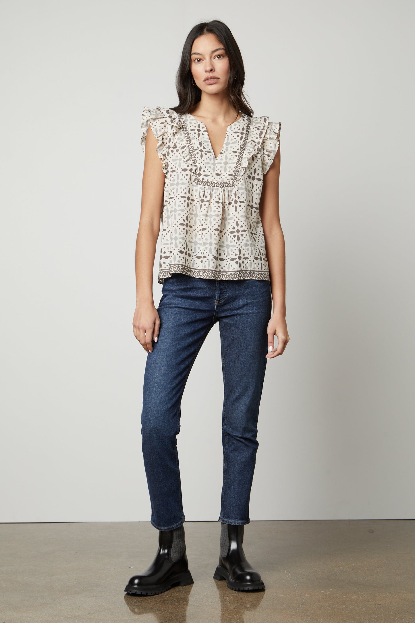 The model is wearing jeans and a CORIN PRINTED TANK TOP by Velvet by Graham & Spencer with ruffled sleeves.-26727056179393