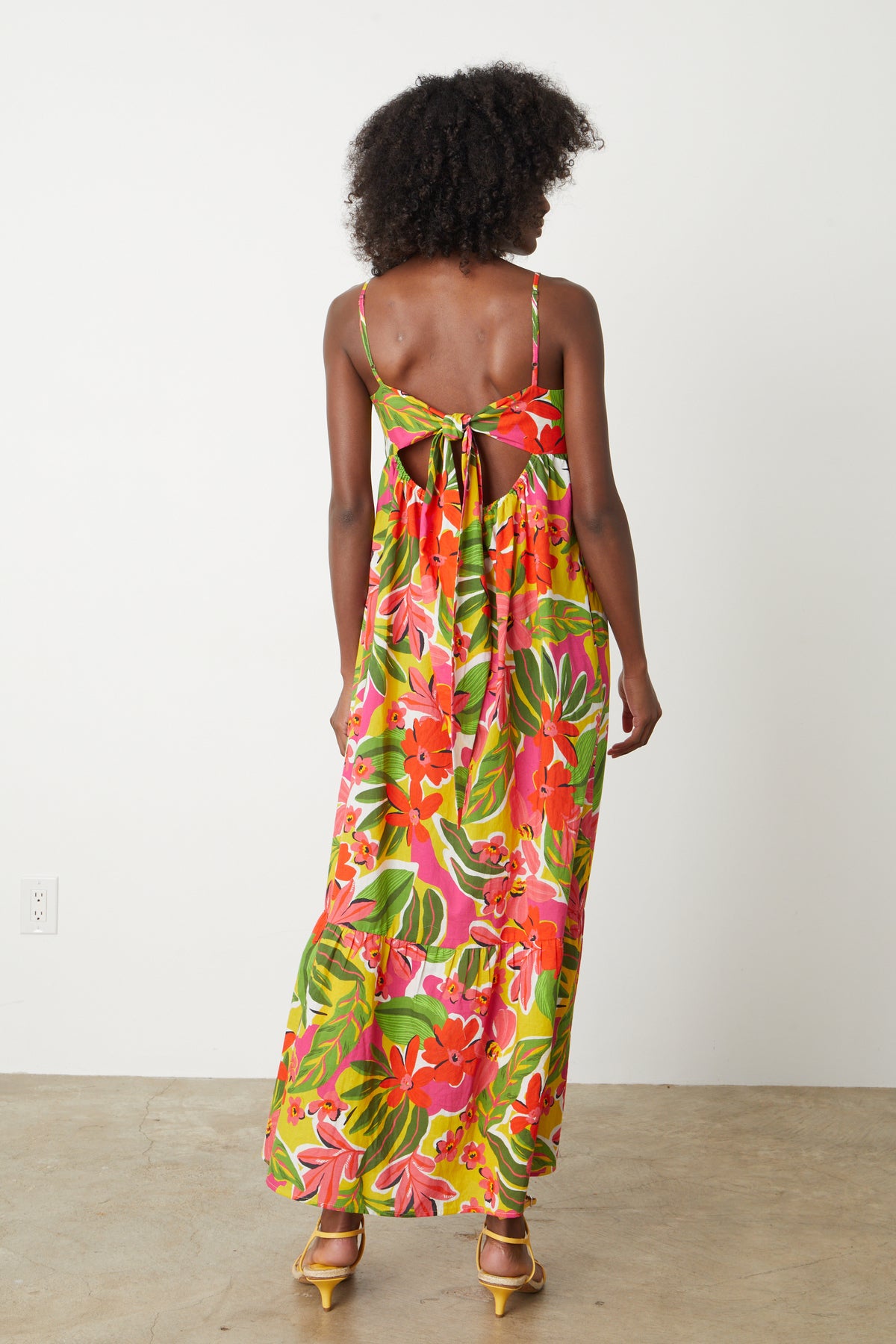   The back view of a woman wearing a Velvet by Graham & Spencer Kayla printed maxi dress. 