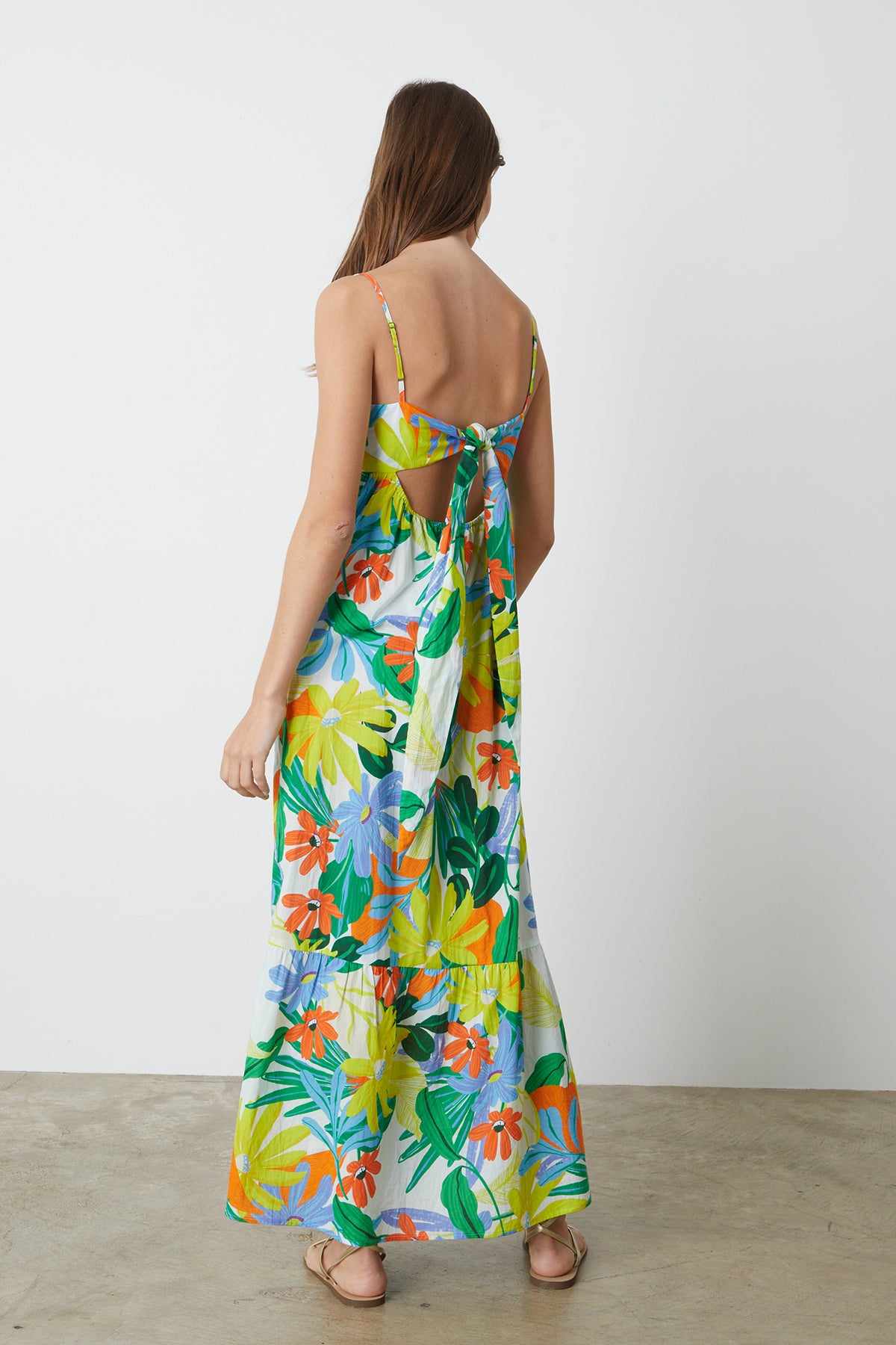   The back view of a woman wearing a Velvet by Graham & Spencer KAYLA PRINTED MAXI DRESS. 