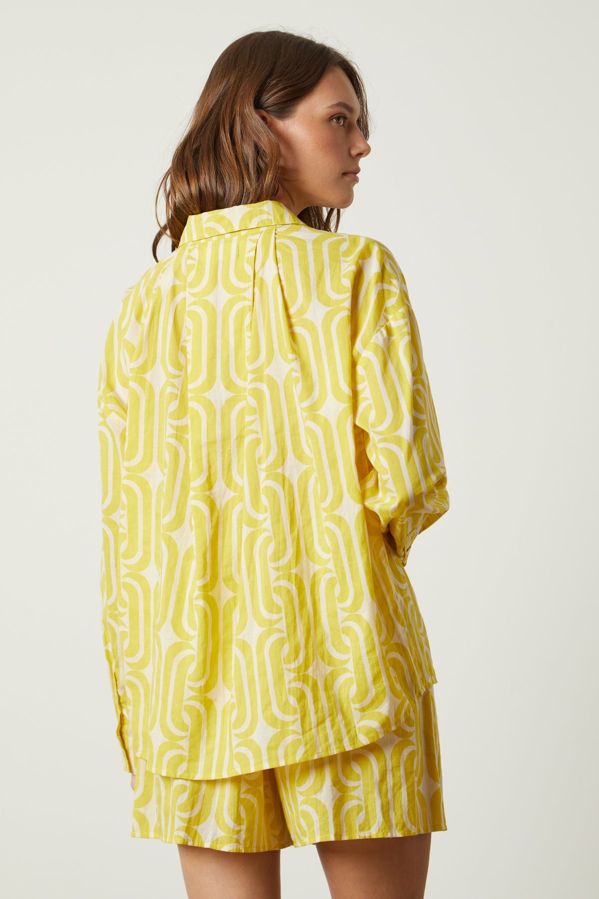   A woman wearing a yellow Velvet by Graham & Spencer ANNALISE printed top and shorts. 