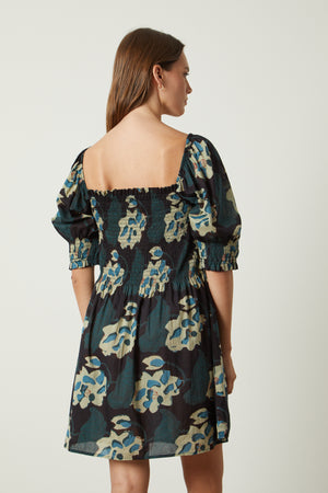 The back view of a woman wearing a Velvet by Graham & Spencer RAMIRA PRINTED DRESS.