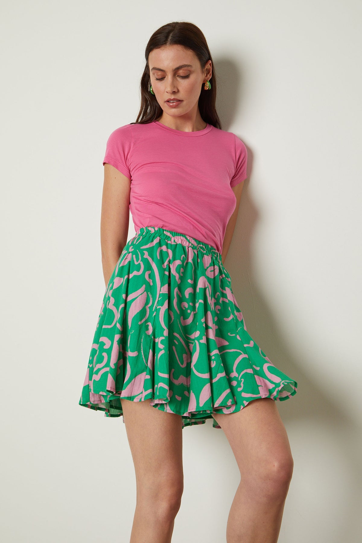   a woman wearing a Velvet by Graham & Spencer JEMMA GAUZY WHISPER FITTED CREW NECK TEE and green skirt. 