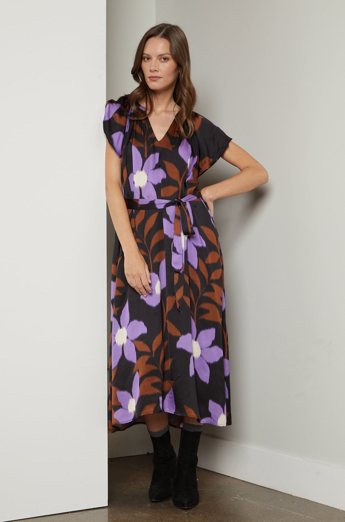   A woman wearing a soft Velvet by Graham & Spencer FRANCINE PRINTED MIDI DRESS with a V-neckline. 