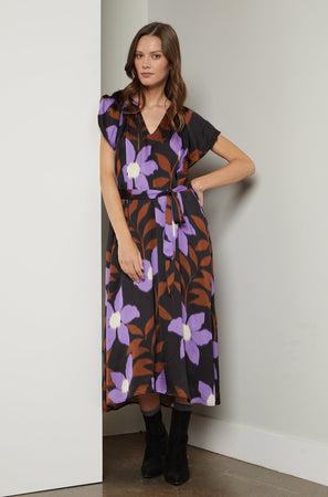 A woman wearing a soft Velvet by Graham & Spencer FRANCINE PRINTED MIDI DRESS with a V-neckline.