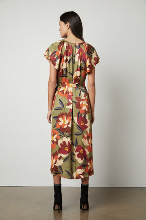 The back view of a woman wearing the Velvet by Graham & Spencer FRANCINE PRINTED MIDI DRESS with a V-neckline.