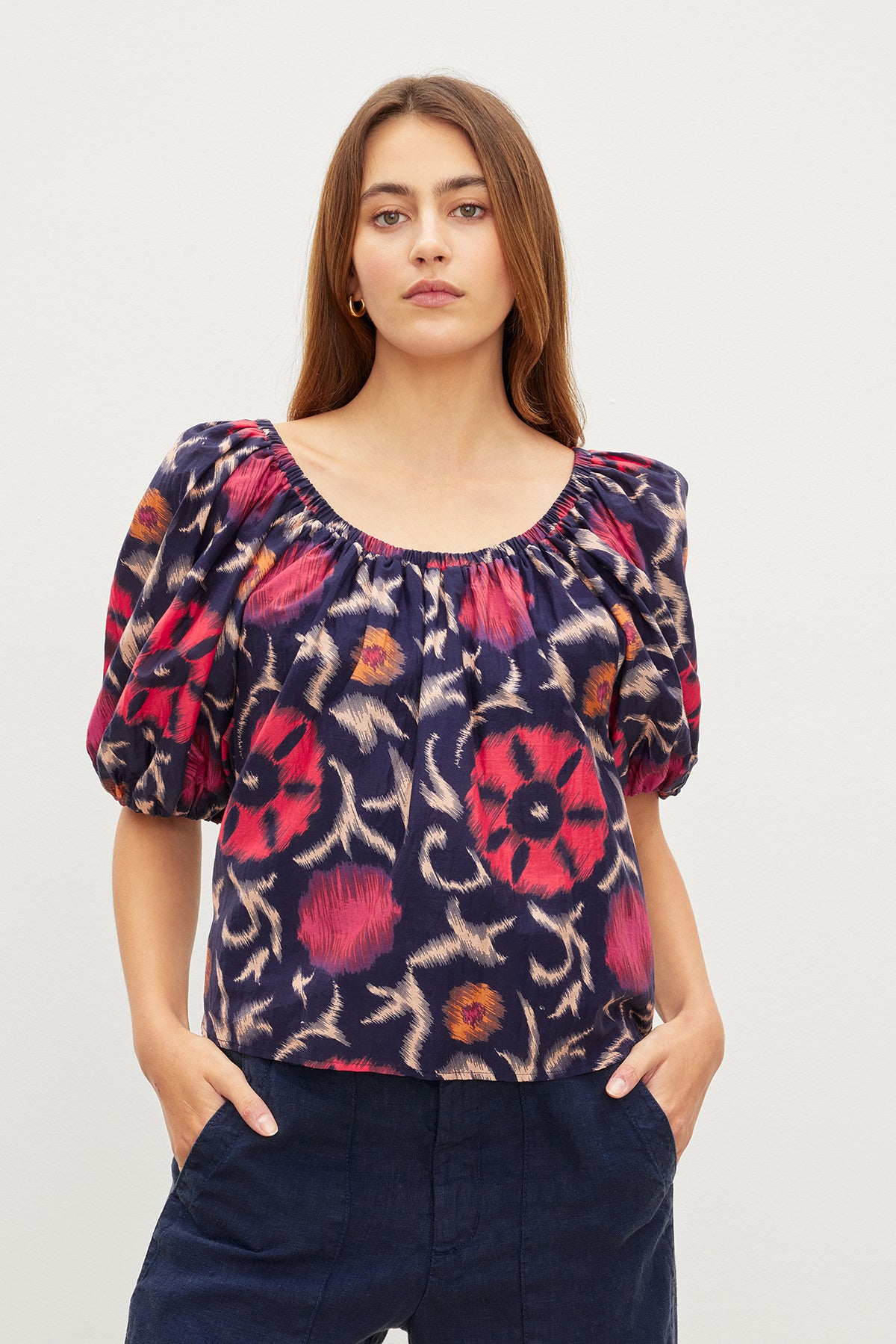The model is wearing a Velvet by Graham & Spencer EDLIN PRINTED SILK COTTON VOILE TOP with a floral print.-35982321942721