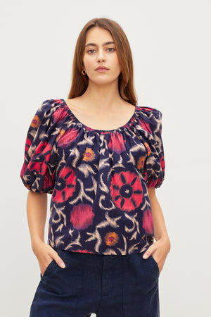 The model is wearing a Velvet by Graham & Spencer EDLIN PRINTED SILK COTTON VOILE TOP with a floral print.