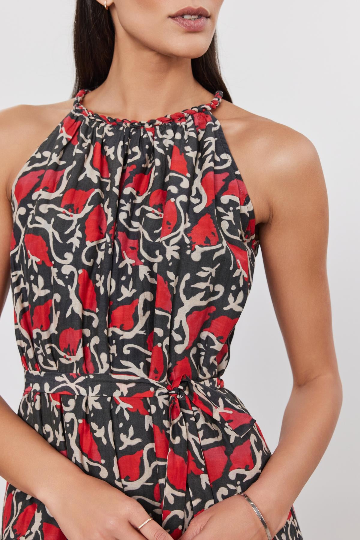 Woman wearing a GHITA DRESS by Velvet by Graham & Spencer, a red, black, and white patterned silk cotton voile dress with a halter-style neckline and a tie at the waist.-36910024556737