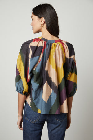 The back view of a woman wearing a Velvet by Graham & Spencer LIZETTE PRINTED BOHO TOP.