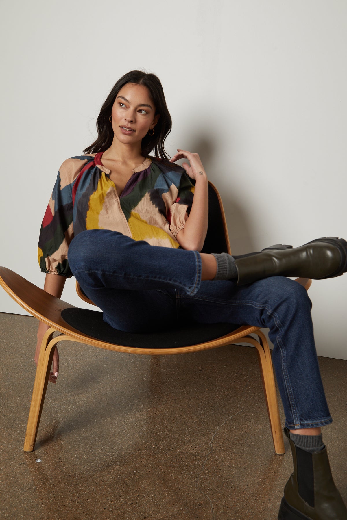   A woman sitting in a chair wearing Velvet by Graham & Spencer jeans and boots. 