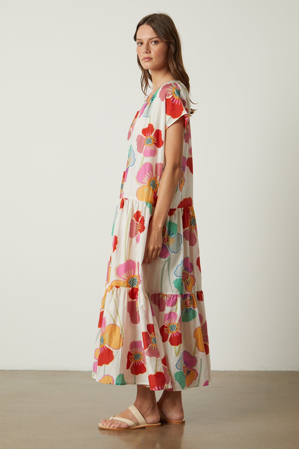 A woman wearing a multi-colored floral Savannah Printed Maxi Dress by Velvet by Graham & Spencer.-26317107953857