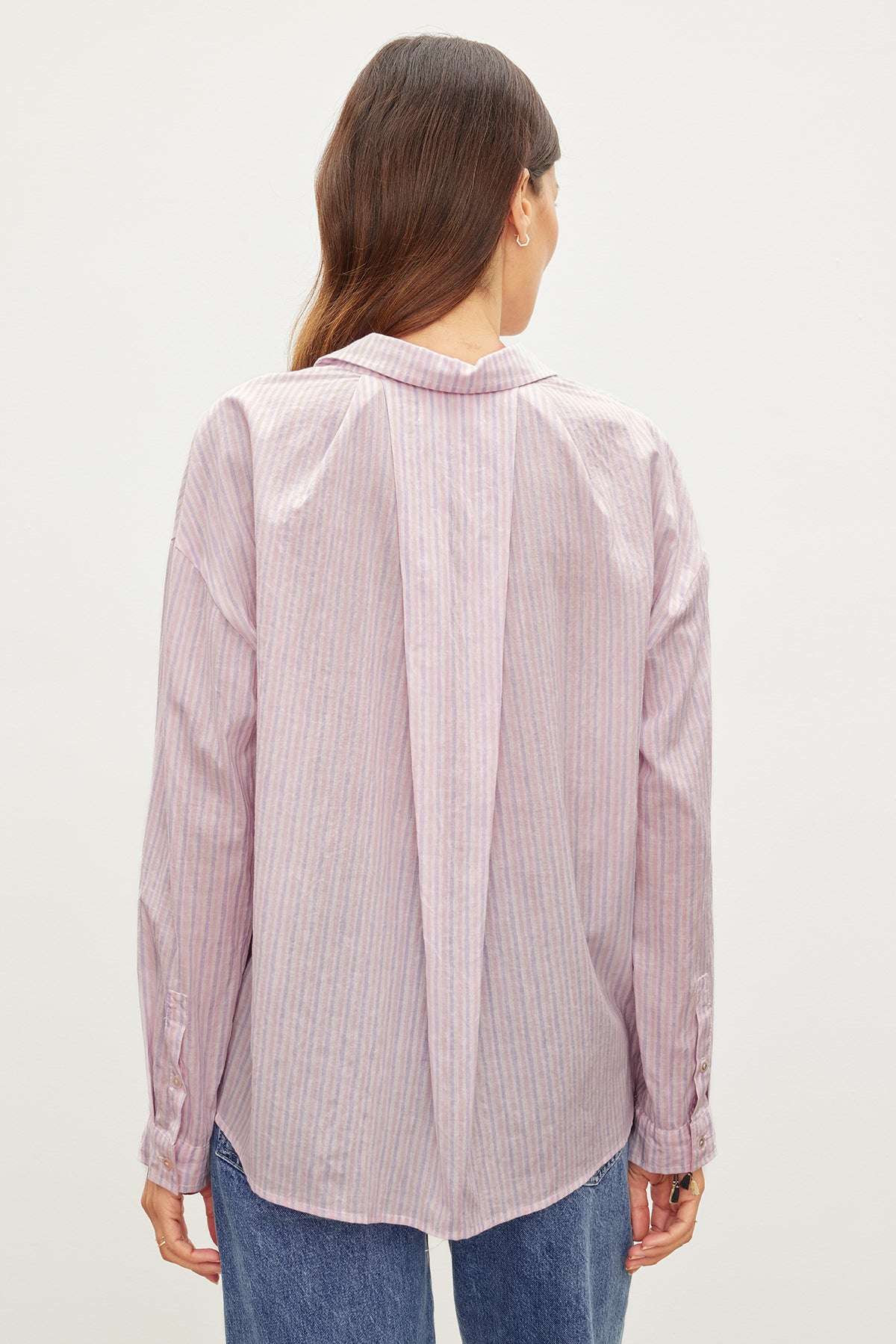 The back view of a woman wearing Velvet by Graham & Spencer's ASHLYN STRIPED BUTTON-UP SHIRT, a wardrobe staple.-35955417972929