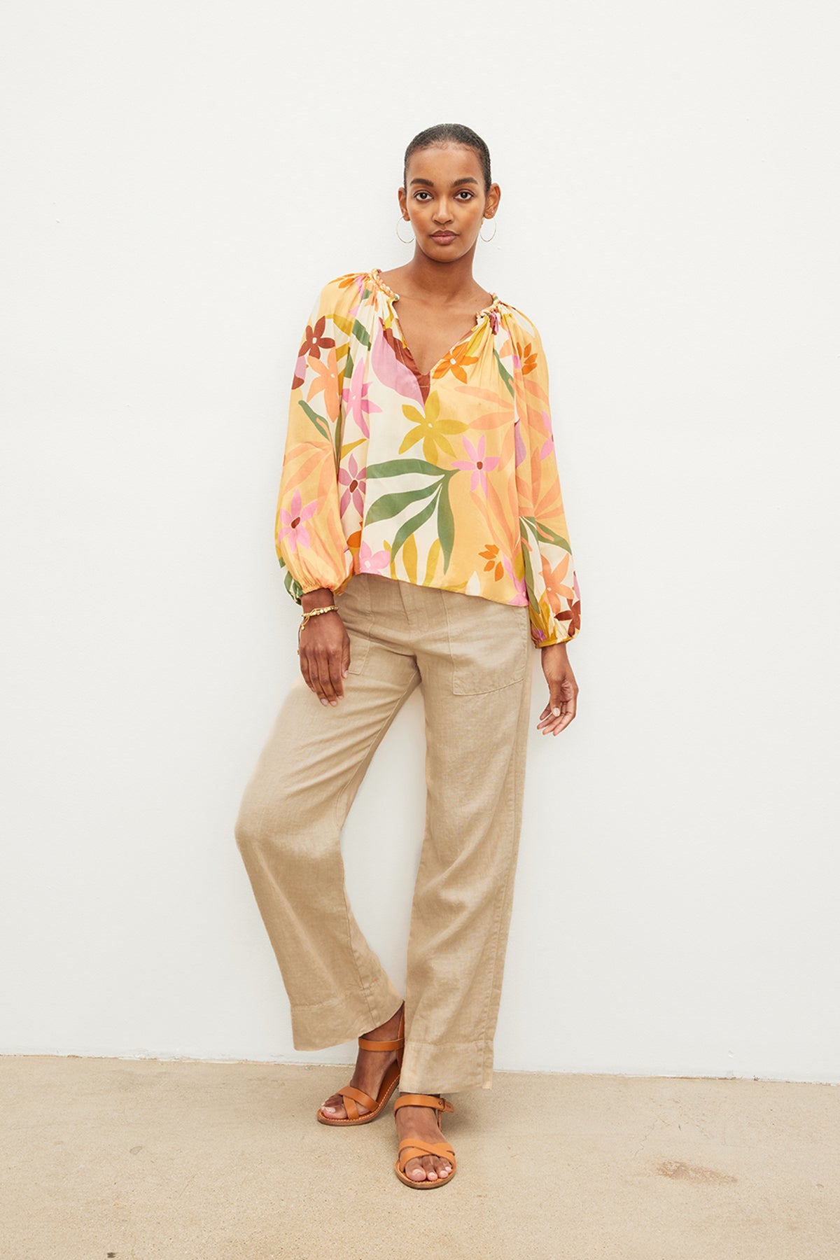 A woman wearing a Velvet by Graham & Spencer DION PRINTED BOHO TOP and tan wide leg pants.-35955700728001