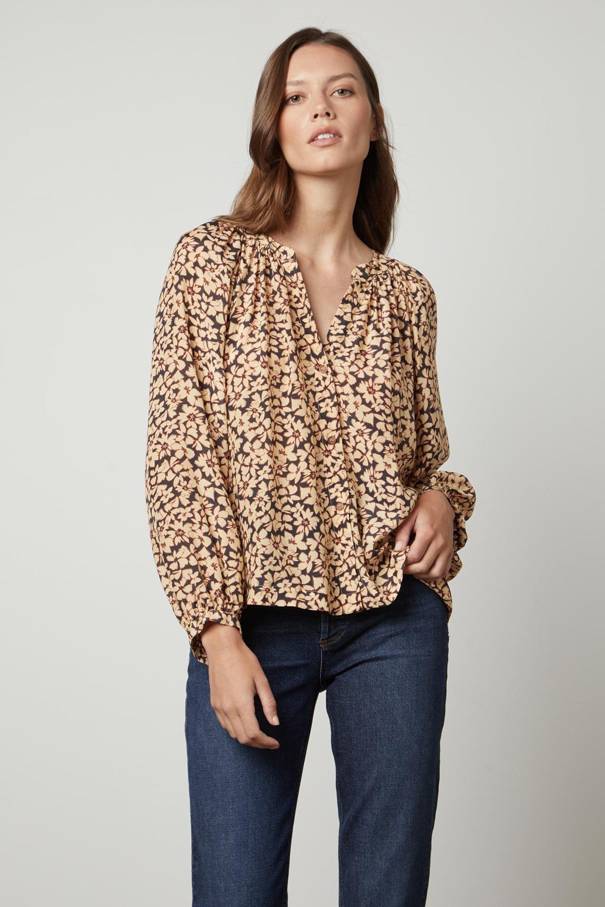   A person wearing jeans and a MELINDA PRINTED BUTTON-UP TOP by Velvet by Graham & Spencer with a leopard print. 