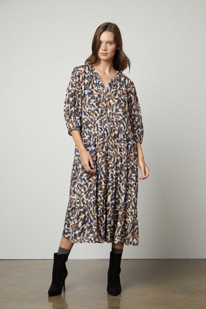 The model is wearing the Velvet by Graham & Spencer OTTILIE PRINTED BOHO DRESS.