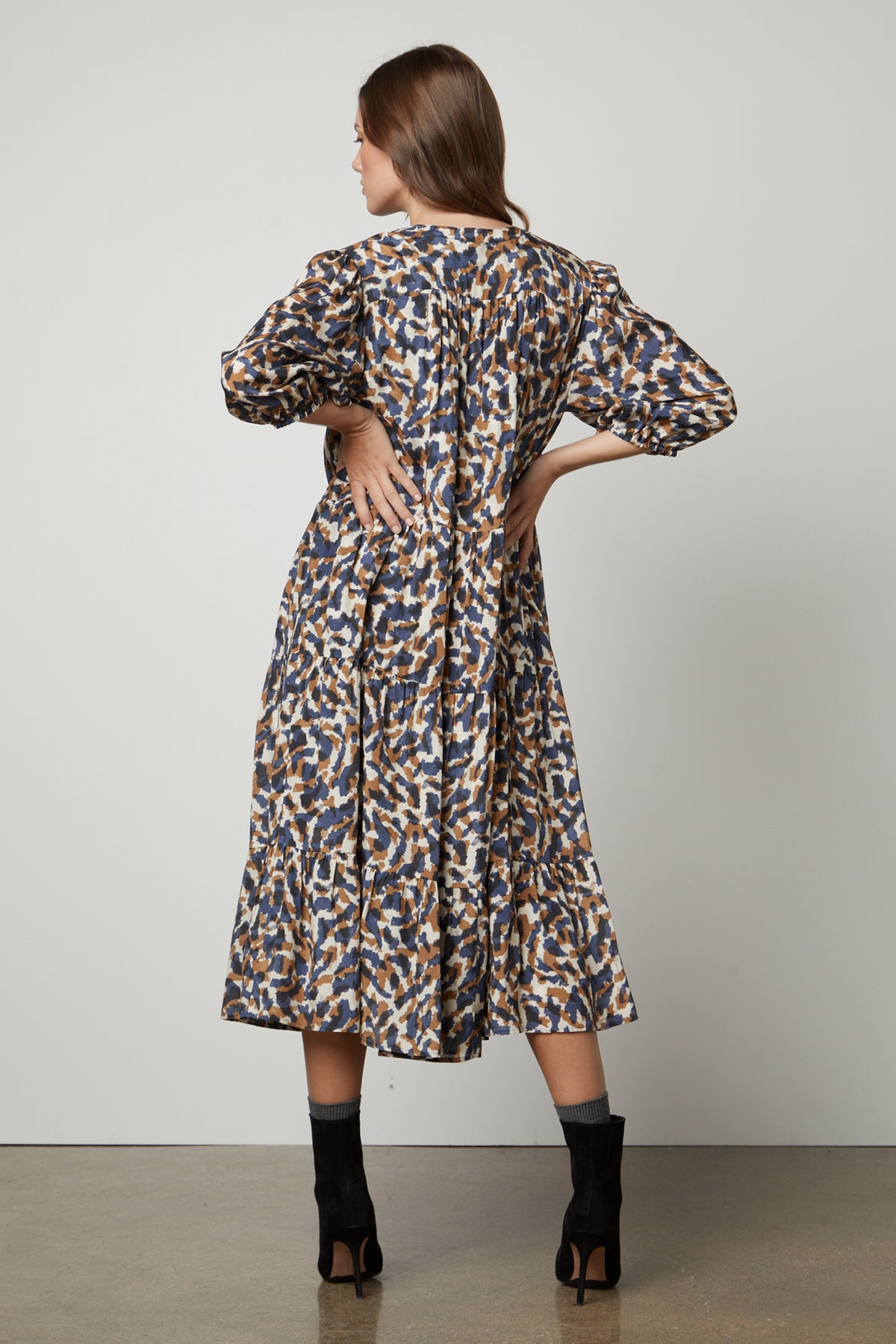   The back view of a woman wearing Velvet by Graham & Spencer's OTTILIE PRINTED BOHO DRESS with elastic cuffs. 