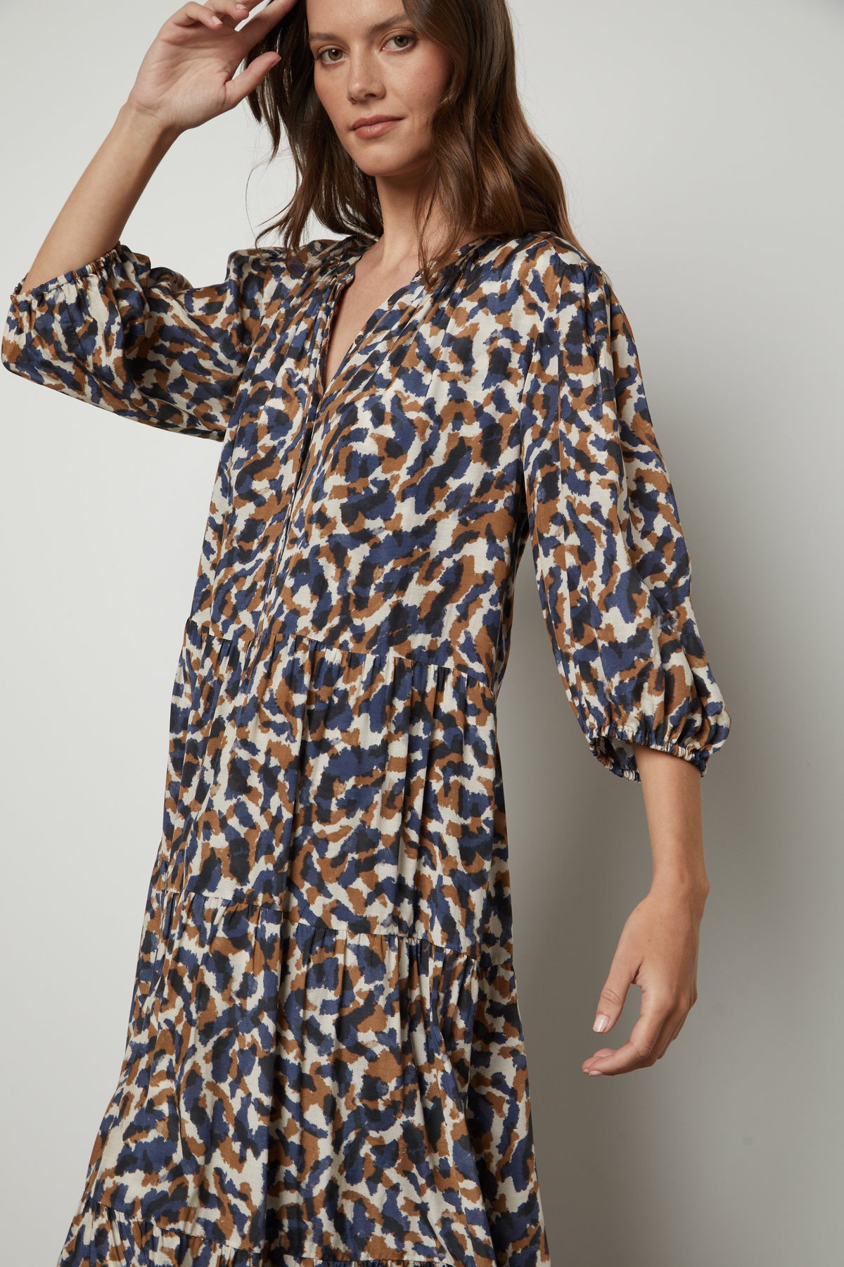 The model is wearing a blue and brown button front Velvet by Graham & Spencer OTTILIE PRINTED BOHO DRESS.-26914793783489