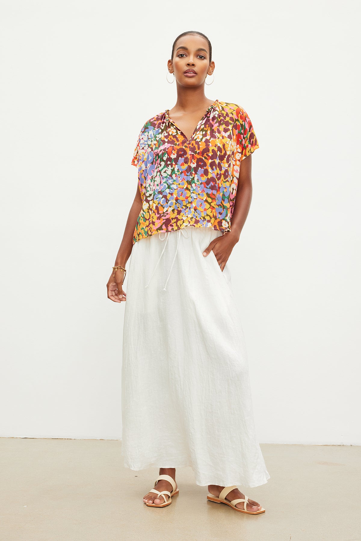 The model is wearing a Velvet by Graham & Spencer TRIXY PRINTED COCOON TOP and white wide leg pants.-35967708233921