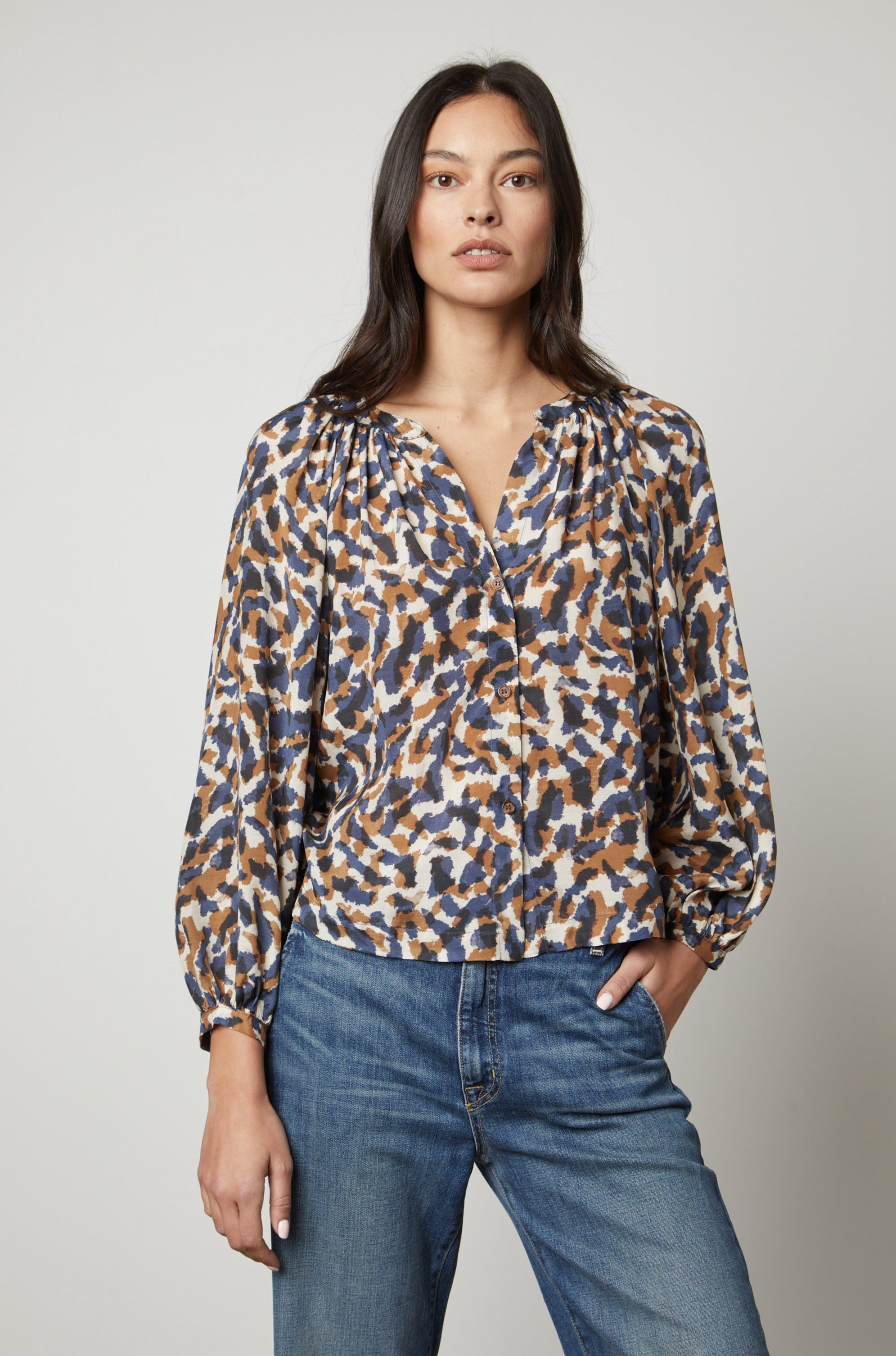   The model is wearing jeans and a Velvet by Graham & Spencer Melinda Printed Button-Up Top. 