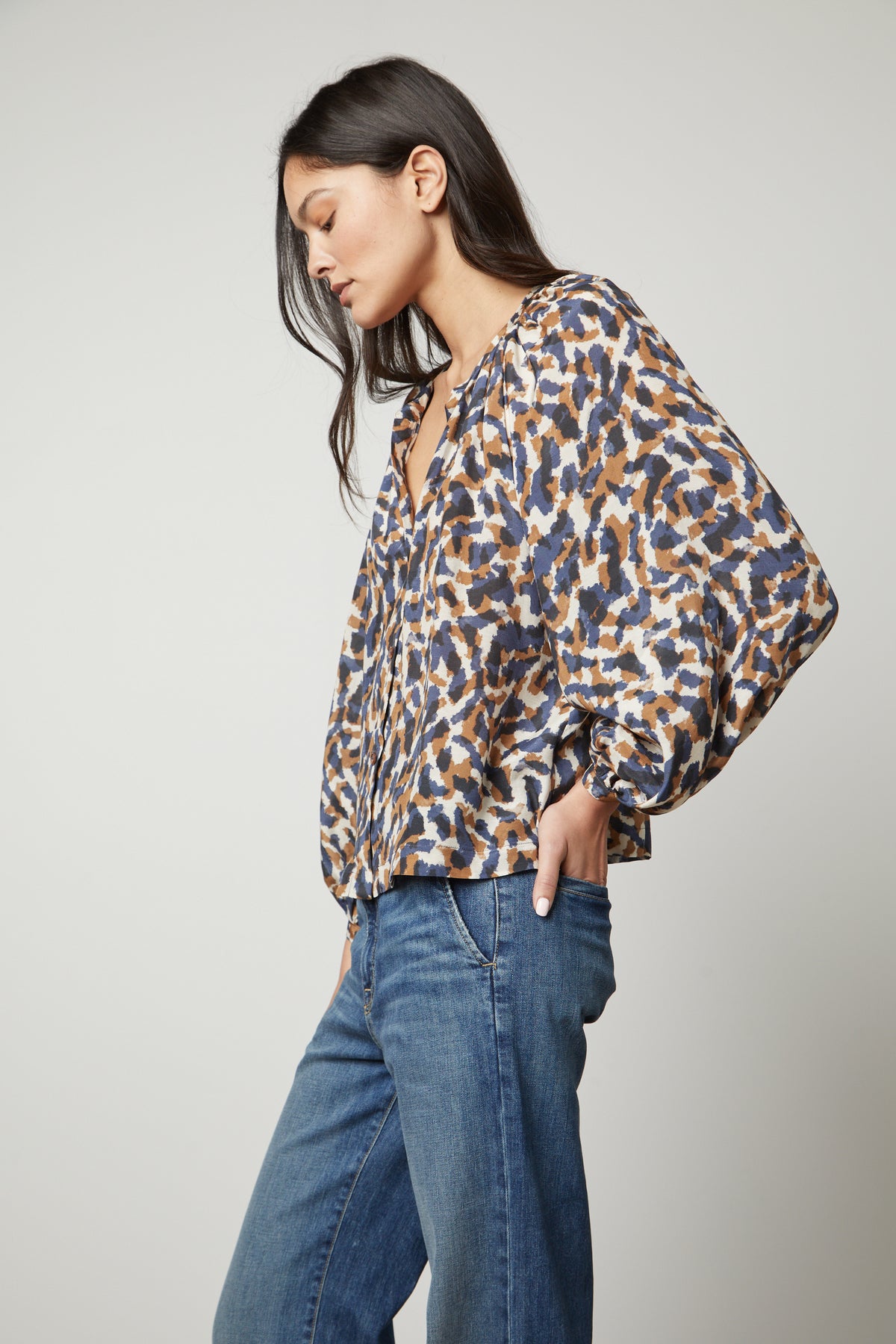The model is wearing jeans and a printed button-up top.-26895474557121