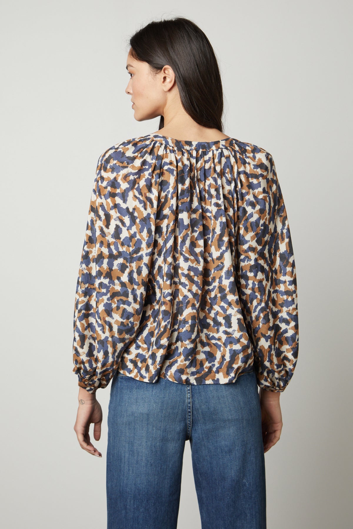   The view of a woman wearing the Velvet by Graham & Spencer MELINDA PRINTED BUTTON-UP TOP blouse. 