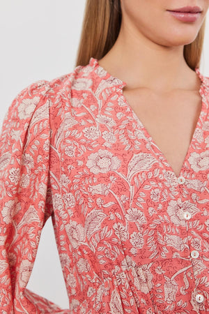 Close-up of a woman wearing a pink floral printed cotton voile MARY DRESS with a v-neckline and button details by Velvet by Graham & Spencer.