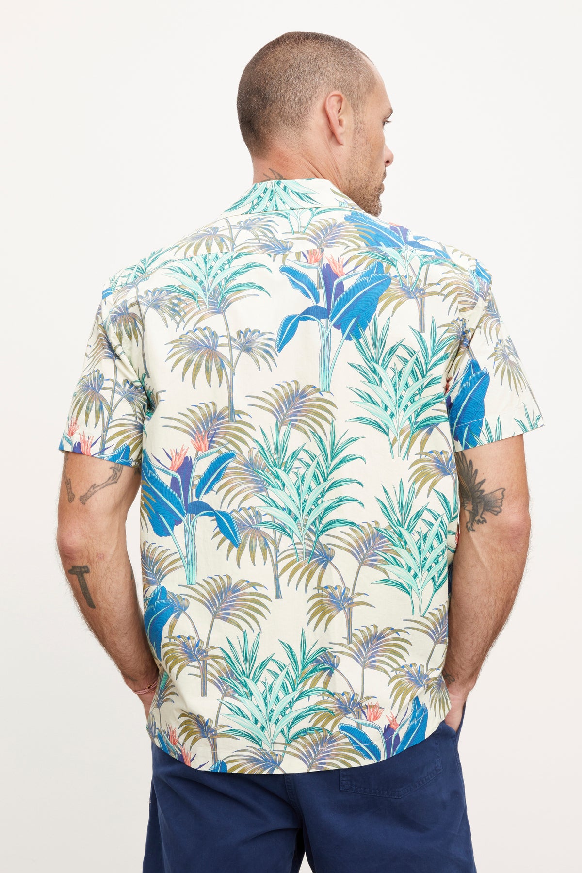   A man wearing the Velvet by Graham & Spencer Iggy Button-Up Shirt standing with his back to the camera, looking to his right side, against a white background. 