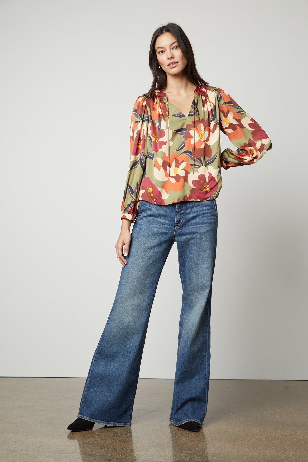 Woman standing in a pose wearing a Velvet by Graham & Spencer Isra Printed V-Neck Blouse and wide-leg jeans for a timeless look.-36328537653441