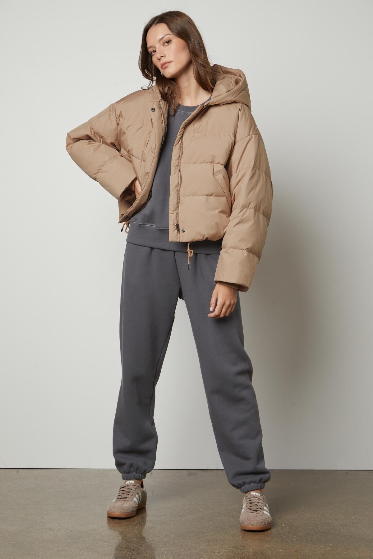 A woman wearing a beige puffer jacket and Velvet by Graham & Spencer's CELESTA SWEATPANT.-26921336176833