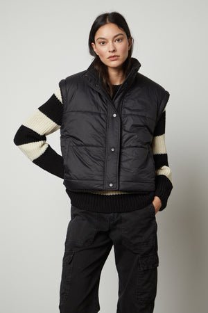 The model is wearing a ALICIA REVERSIBLE PUFFER SHERPA VEST by Velvet by Graham & Spencer.