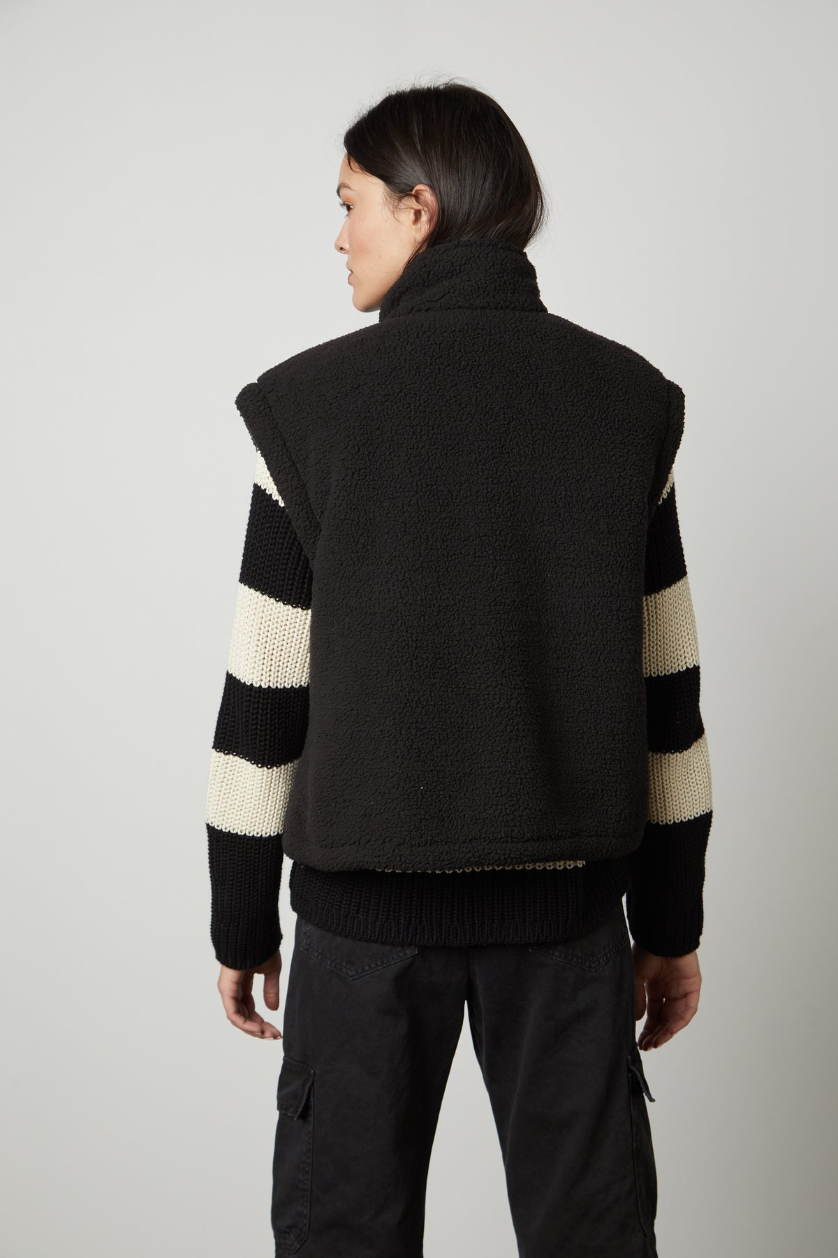 The back view of a woman wearing the Velvet by Graham & Spencer ALICIA REVERSIBLE PUFFER SHERPA VEST.-26897854038209