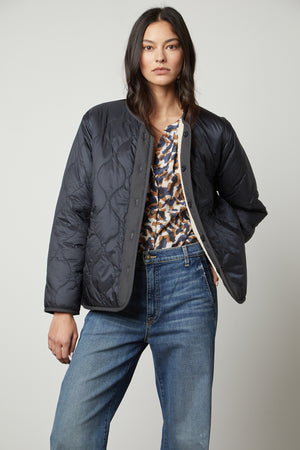 A utilitarian model wearing a Velvet by Graham & Spencer Marissa Reversible Quilted Sherpa Jacket.