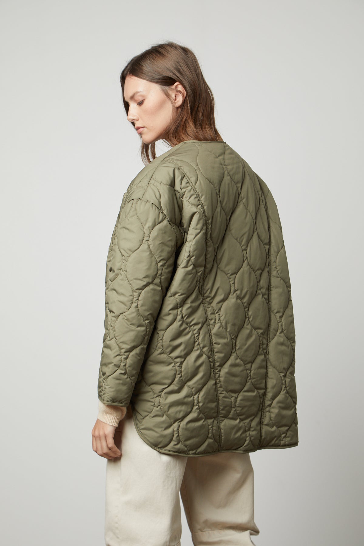   The back view of a woman wearing a Velvet by Graham & Spencer PAITYN QUILTED JACKET with quilted lining. 