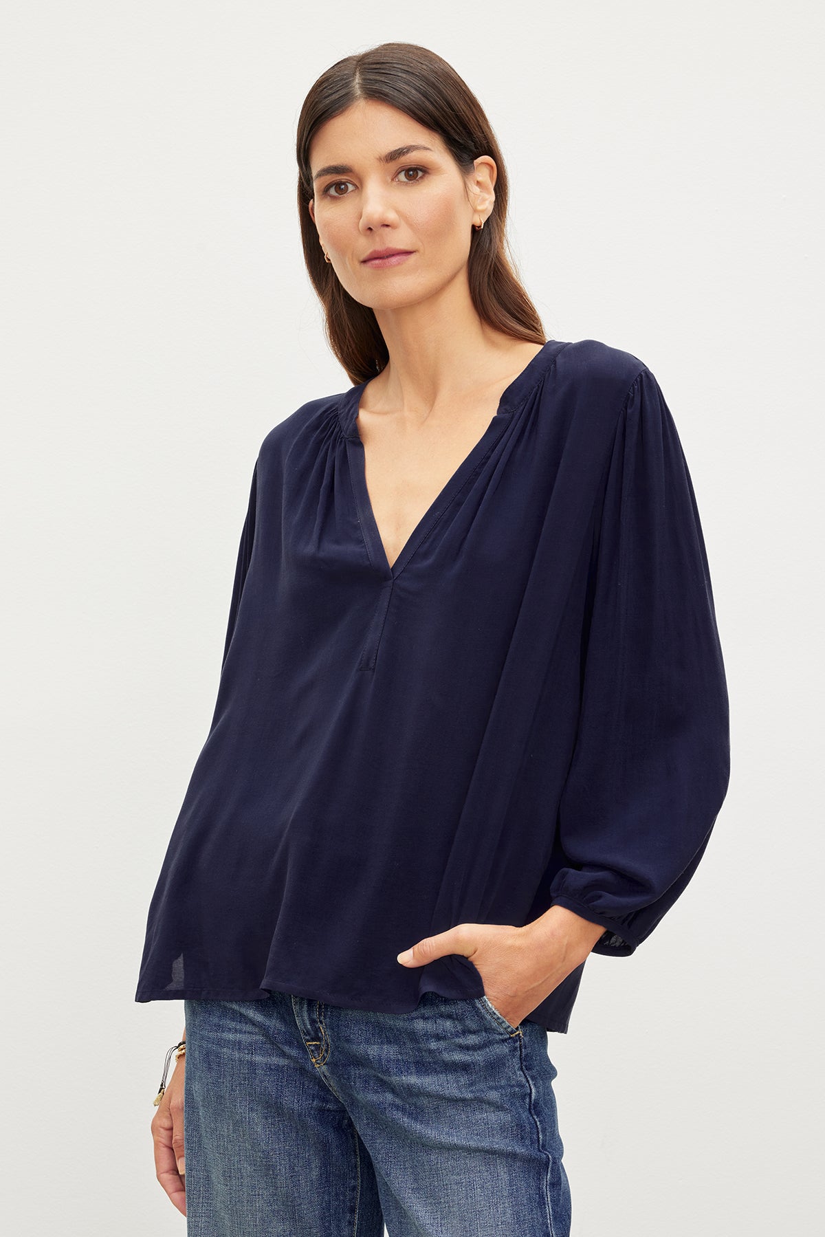 A woman in a Velvet by Graham & Spencer ASHLEY V-NECK TOP posing for a picture.-35955417055425