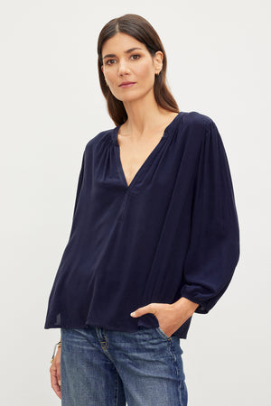 A woman in a Velvet by Graham & Spencer ASHLEY V-NECK TOP posing for a picture.