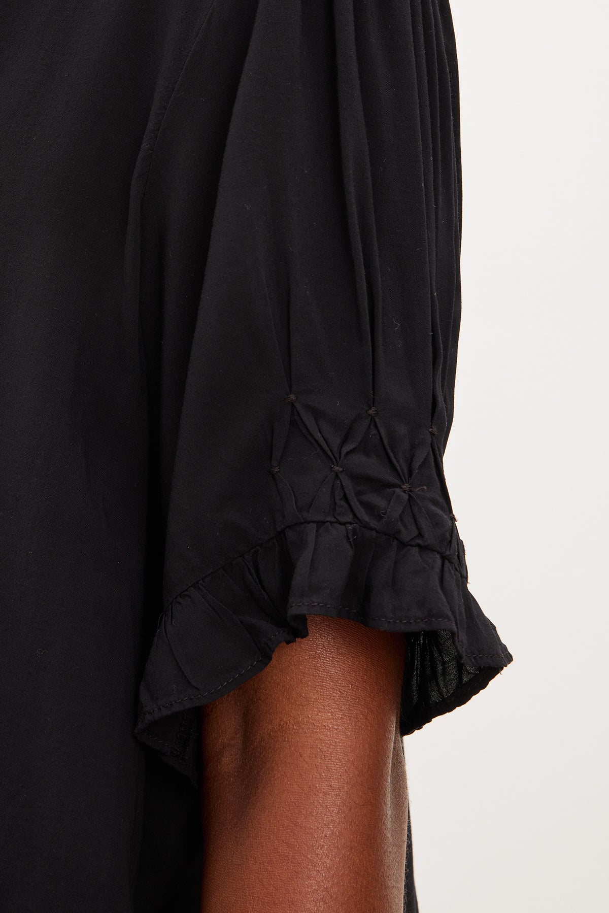 A close up of a woman wearing a Velvet by Graham & Spencer Calissa Split Neck Blouse with ruffled sleeves made from rayon challis.-35955491012801