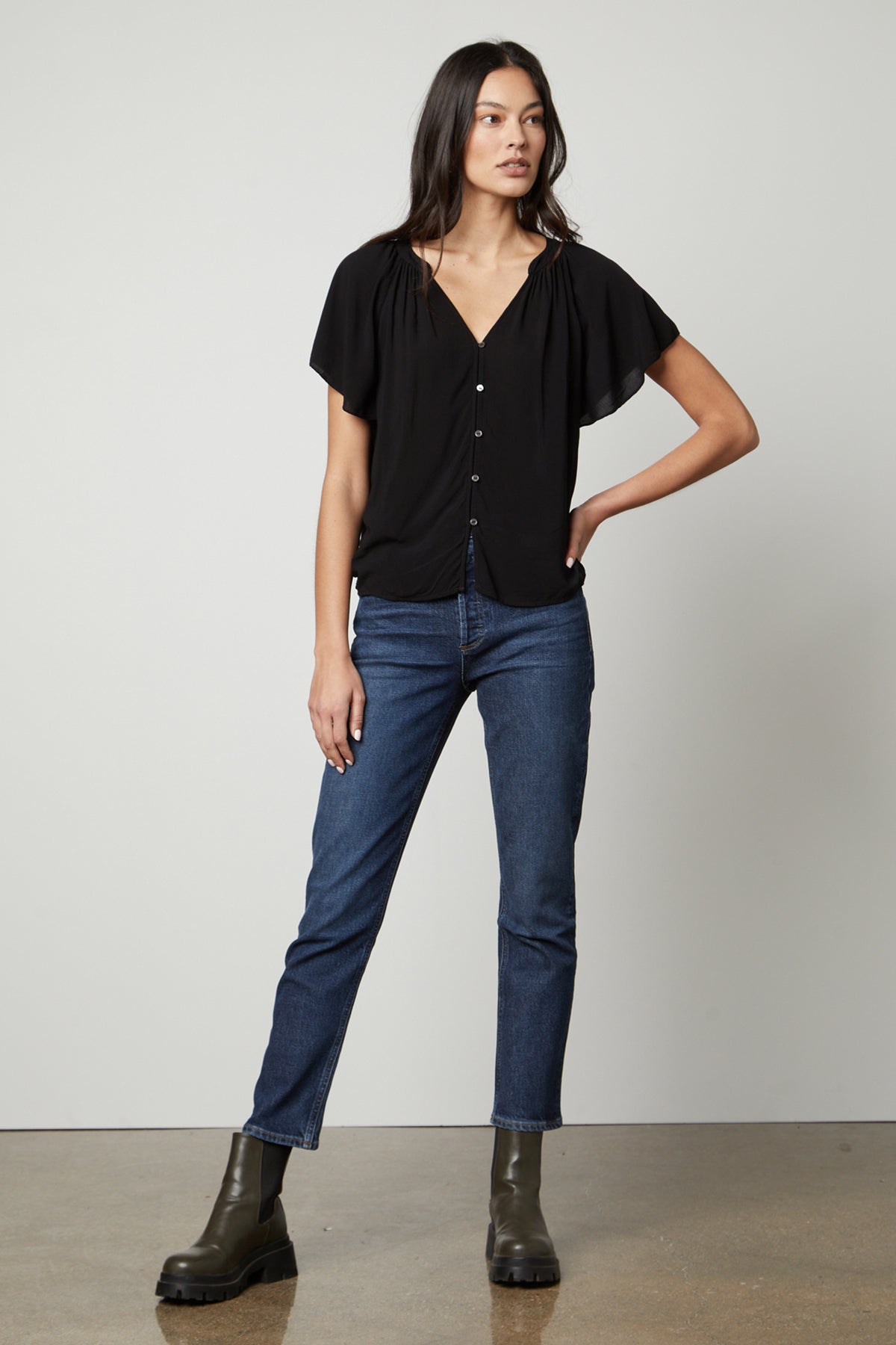   The Harley Flutter Sleeve top in black by Velvet by Graham & Spencer with jeans and boots full length front 