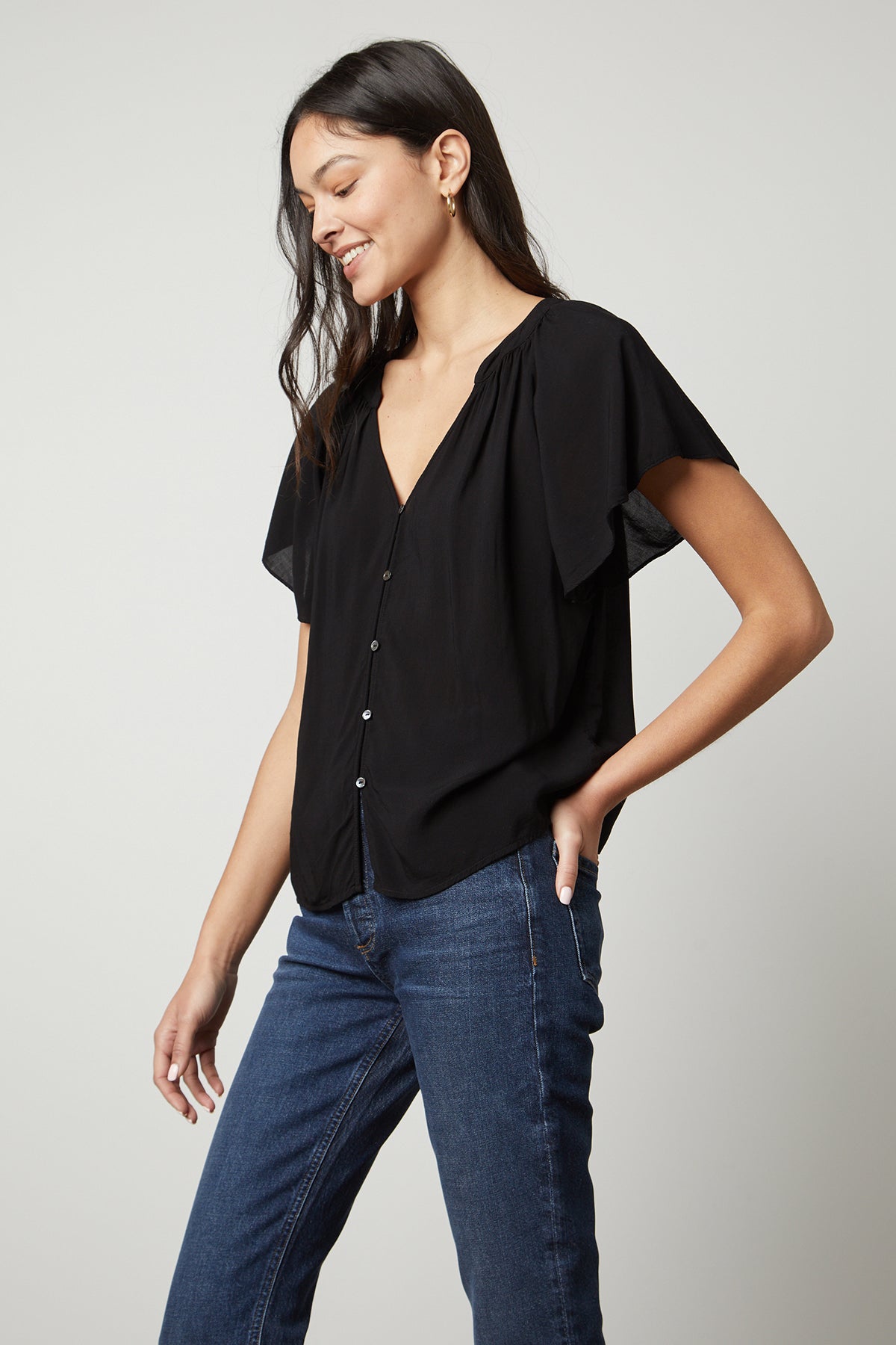 The model is wearing black jeans and a Velvet by Graham & Spencer HARLEY FLUTTER SLEEVE TOP.-26727735394497