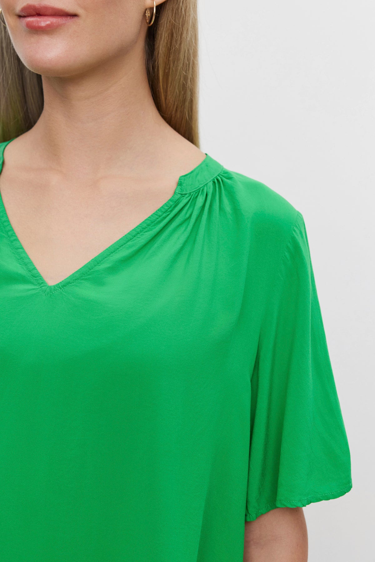   A woman wearing a Velvet by Graham & Spencer JAYCEE SPLIT NECK BLOUSE. 